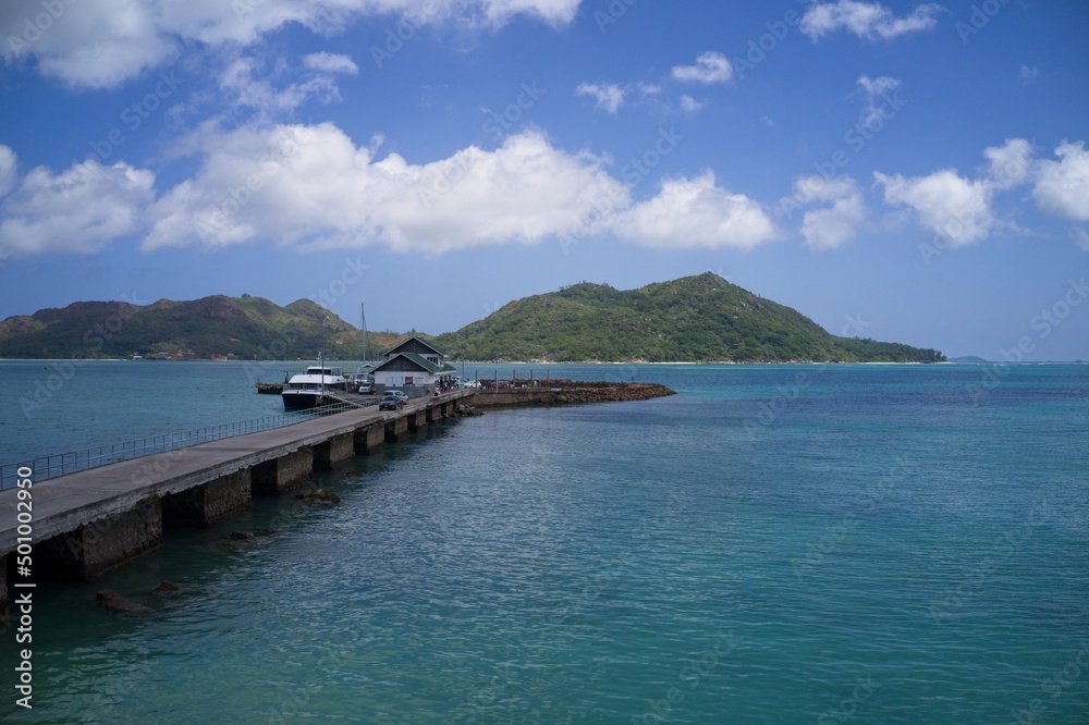 Drone field of view of jetty leading into  harbour with islands in background in Praslin, Seychelles.