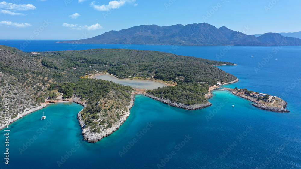 Aerial drone photo of iconic Aponisos bay and lake with clear turquoise sea and pine trees,  Agistri island, Saronic gulf, Greece