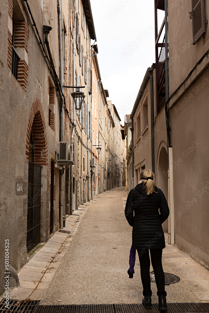 Mujer paseando por una calle de Cahors en Francia.