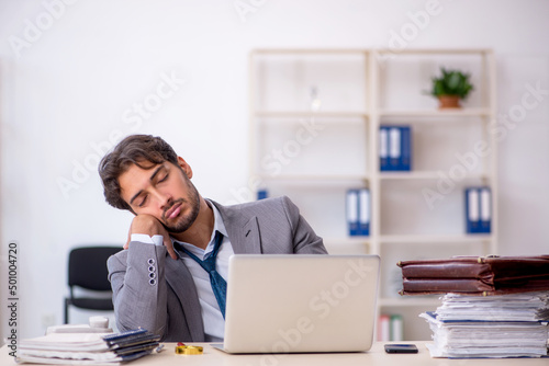 Young male employee in oversleeping concept