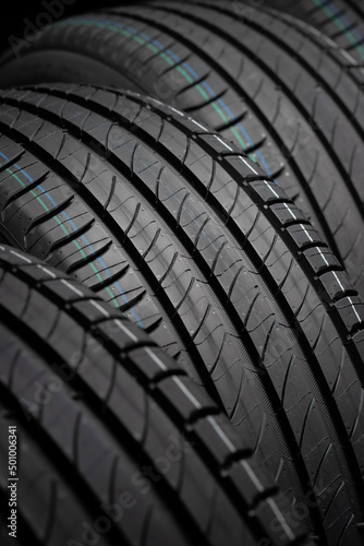 New car tires. Group of road wheels on dark background. Summer Tires with asymmetric tread design. Driving car concept.