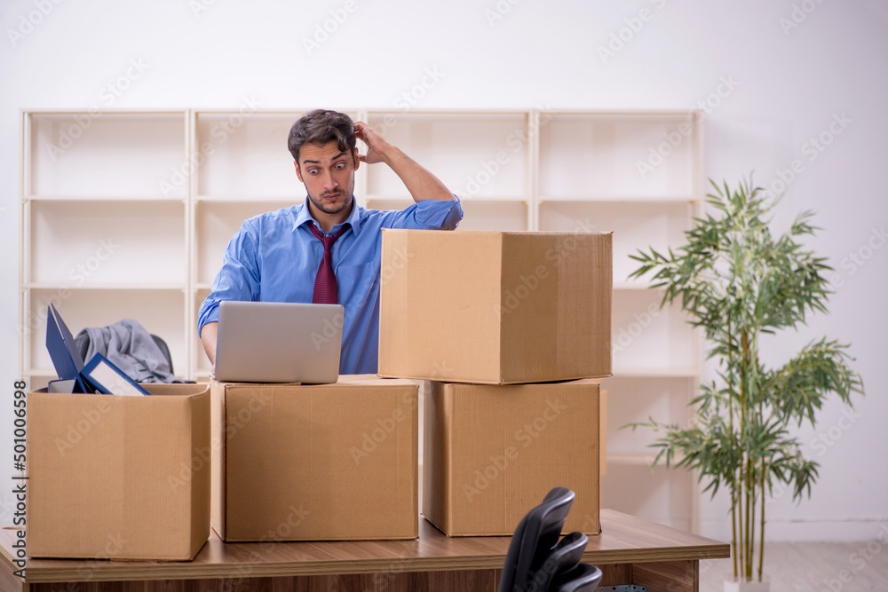 Young male employee in office relocation concept Young male employee in office relocation concept