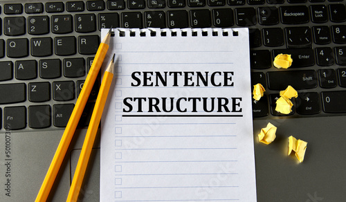 SENTENCE STRUCTURE - words in a white notepad on the background of a laptop with pencils