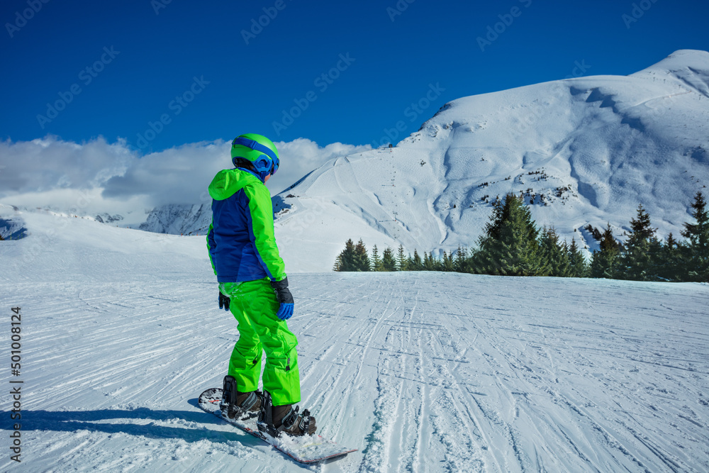 Boy ride snowboard with winter sport outfit on mountain top