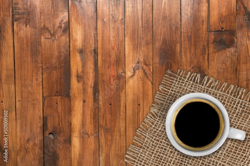 White Cup of Coffee on Wooden desk with burlap napkins