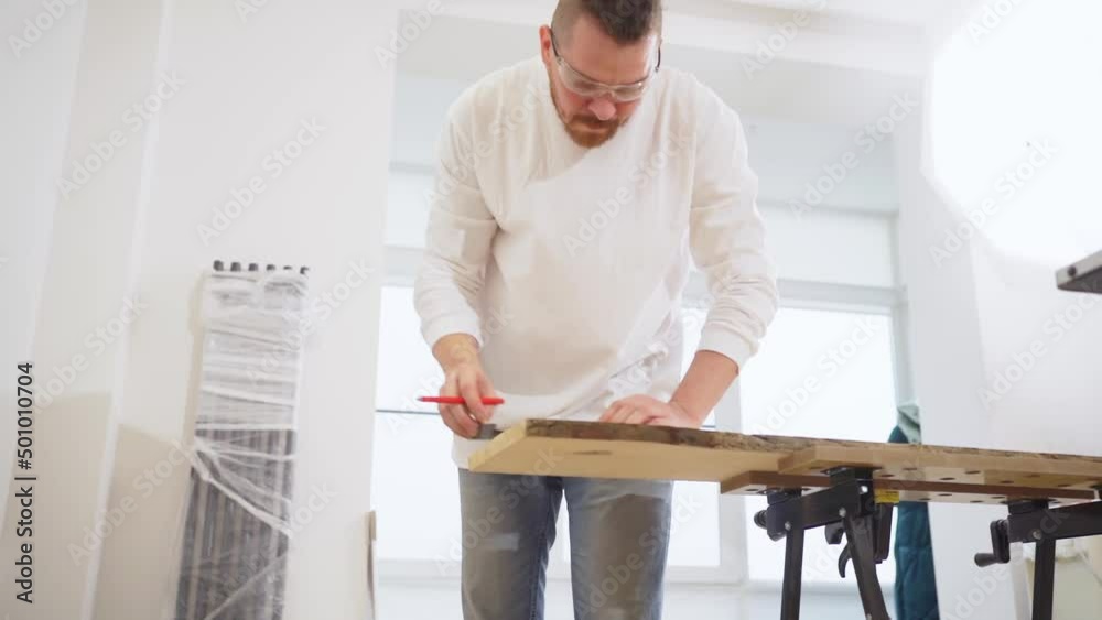 carpenter makes measurements and draws on wood carpenter makes measurements and draws on wood