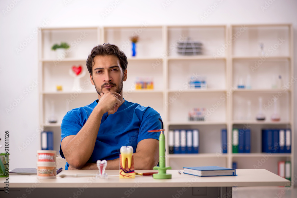 Young male dentist working in the clinic Young male dentist working in the clinic