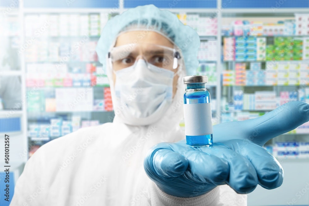 Medical ampule with vaccine in the hands of a doctor. Vaccination awareness concept. Medical ampule with vaccine in the hands of a doctor. Vaccination awareness concept.