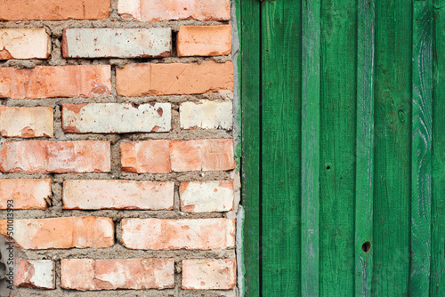 green barn door and red brick wall