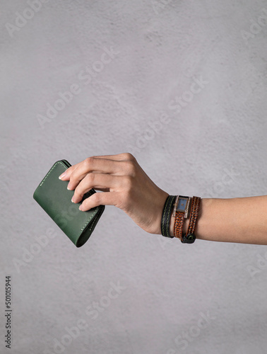 cardholder in a girl's hand with vintage watch. long leather strap