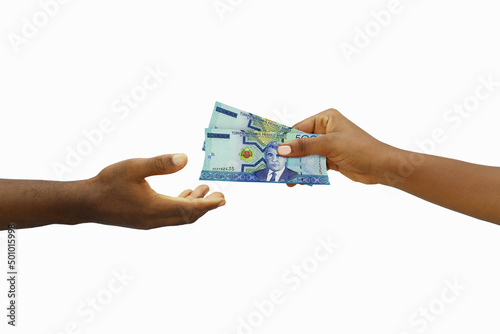 Hand giving 3D rendered Turkmenistani manat notes to another hand. Hand receiving money