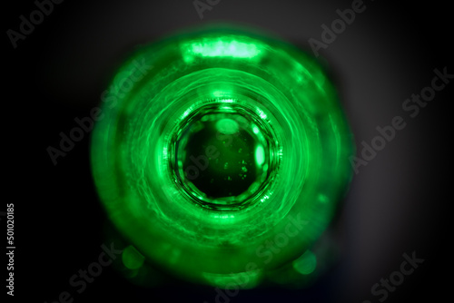 vista cenital de botella de vidrio con agua teñida de verde y poca profundidad de campo