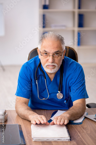 Old male doctor working in the clinic