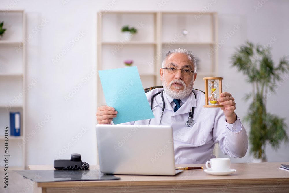 Old male doctor in time management concept Old male doctor in time management concept