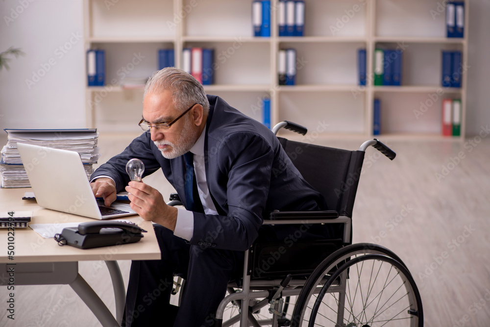 Old male employee in wheel-chair in happy idea concept Old male employee in wheel-chair in happy idea concept