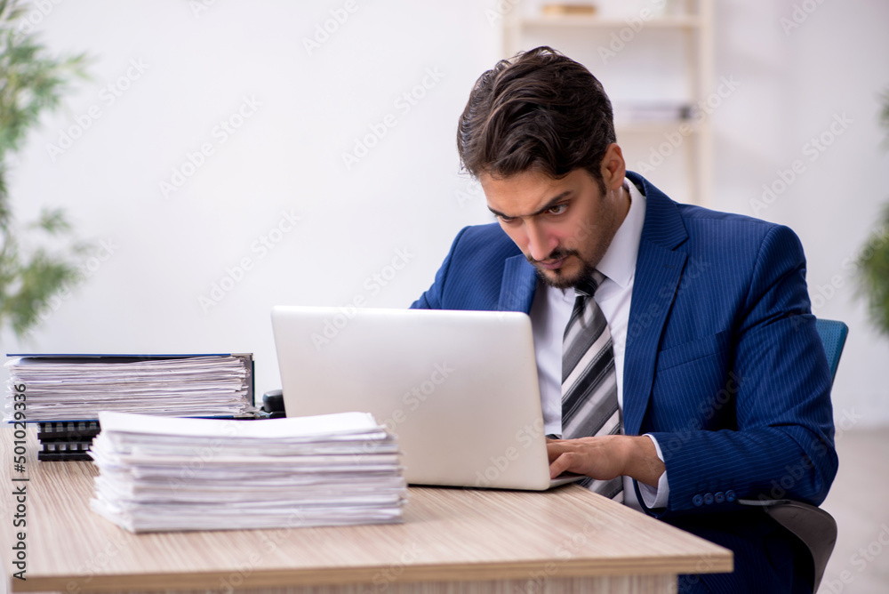 Young male employee working in the office Young male employee working in the office