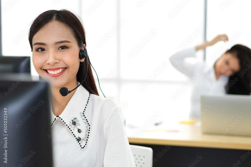 Group of happy call center smiling business operator customer help support team phone services agen working and talking with headset on desktop computer at call center office Group of happy call center smiling business operator customer help support team phone services agen working and talking with headset on desktop computer at call center office