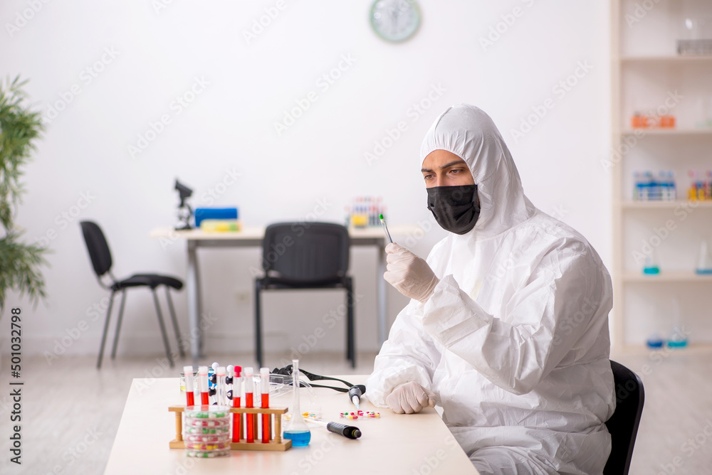 Young male chemist in drugs synthesis concept Young male chemist in drugs synthesis concept