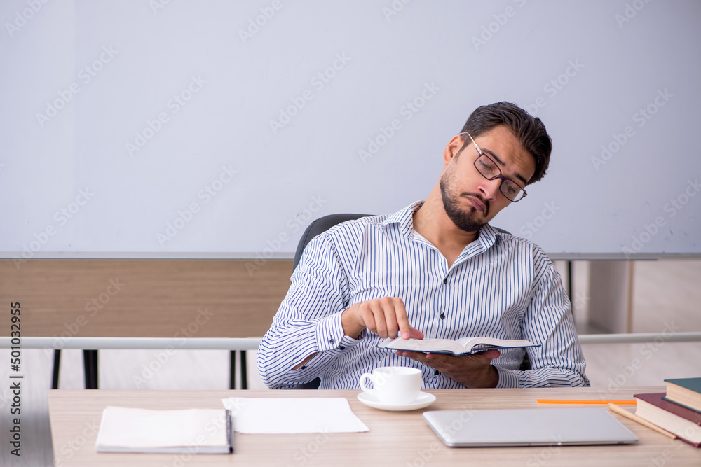Young male teacher in the classroom Young male teacher in the classroom