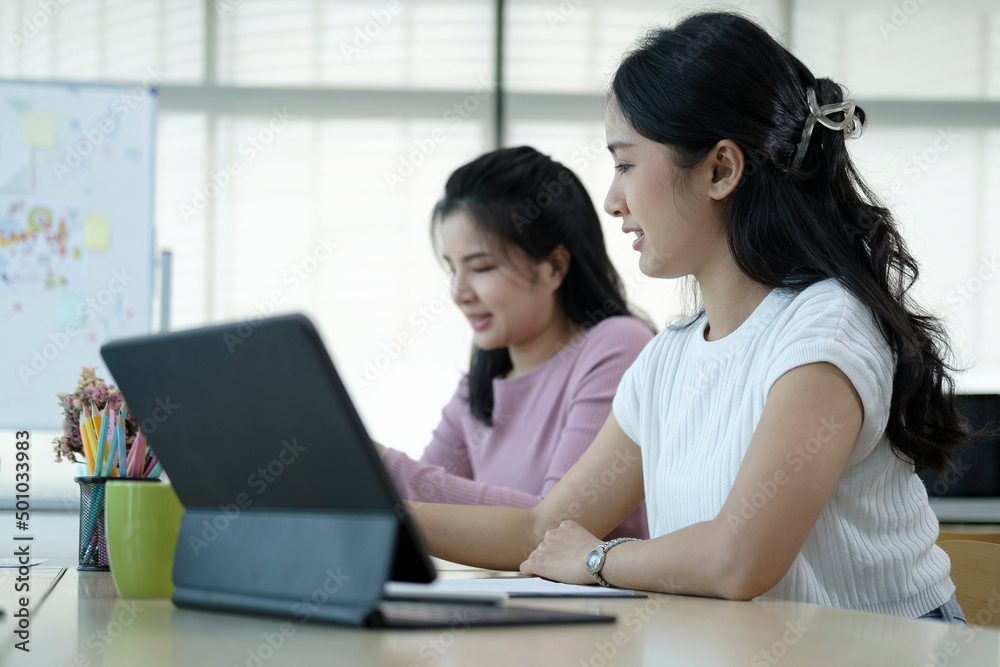 Two creative young women working on project together at modern workplace. Two creative young women working on project together at modern workplace.