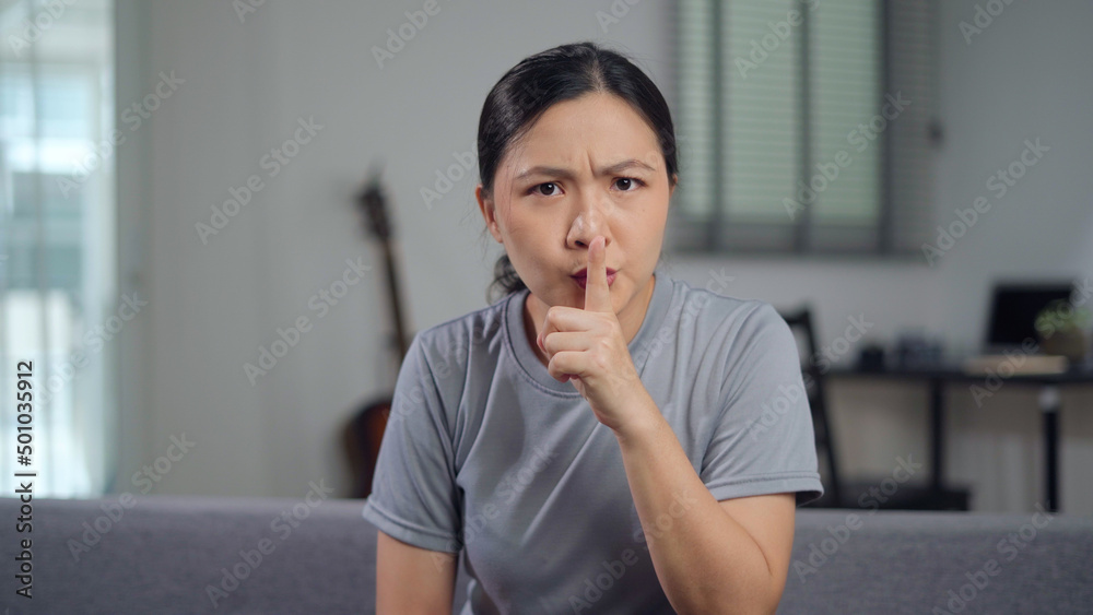 Asian woman putting index finger on lips meaning keeping secret. Asian woman putting index finger on lips meaning keeping secret.
