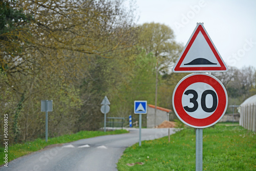 Panneaux annonçant un ralentisseur et limitant la vitesse à 30 kmh.