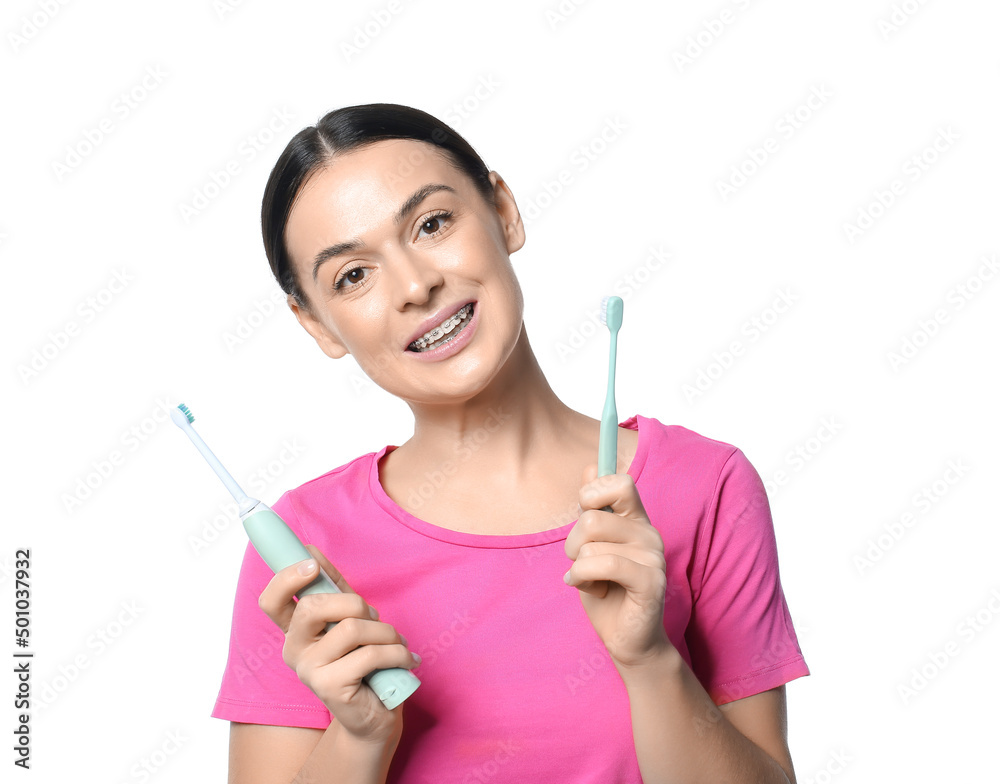 Beautiful woman with dental braces and different tooth brushes on white background Beautiful woman with dental braces and different tooth brushes on white background