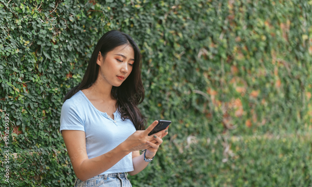 Happy asian woman smiling and holding cellphone while sitting in street summer cafe. Happy asian woman smiling and holding cellphone while sitting in street summer cafe.