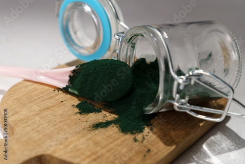 Green spirulina, spirulina powder with spoon. Useful habits, self care and healthy lifestyle.