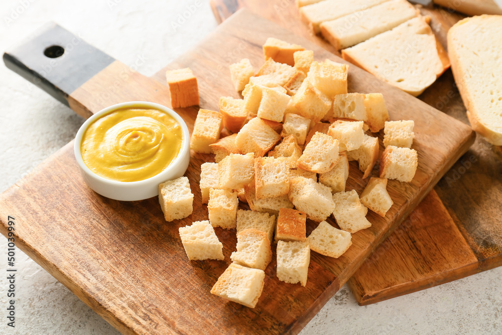 Fototapeta premium Board with tasty croutons and sauce on white background, closeup