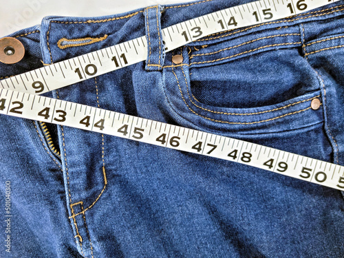 Bilde på lerret Close up of tape measure in denim blue jean waistband