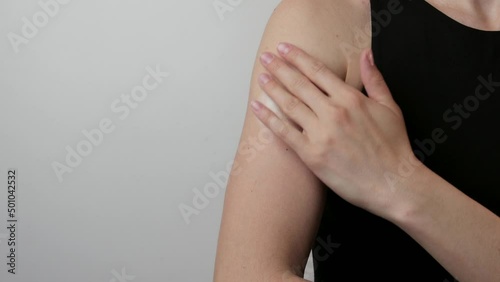 Woman applying a body lotion on her arm to moistures a skin