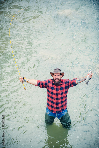Fishing hobby and summer weekend. Bearded men fisher with fishing rod and net. Excited amazed fisher man in water catching trout fish, top view.