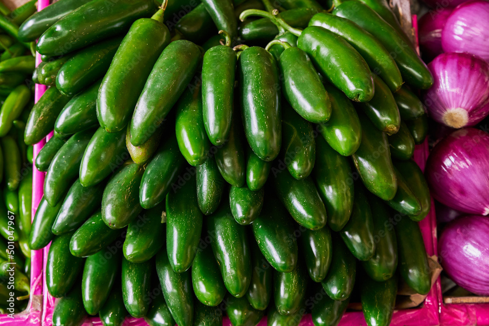 Jalapeño peppers placed on a shelf for sale inside a market Jalapeño peppers placed on a shelf for sale inside a market