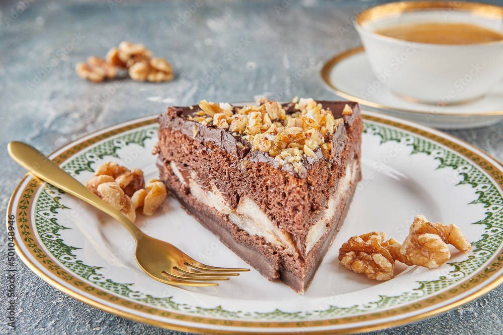 Chocolate cake with pears and walnuts on plate with cup of coffee Chocolate cake with pears and walnuts on plate with cup of coffee