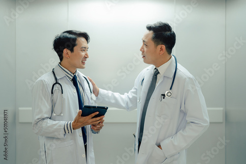 Mature Male Doctor and Doctor talking in the elevator  They Consult and Talking about Patient s Health.