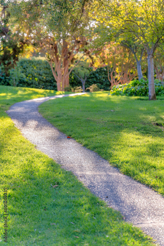 Narrow curved concrete walkway in a field at Japanese Friendship Garden in San Jose, California Narrow curved concrete walkway in a field at Japanese Friendship Garden in San Jose, California