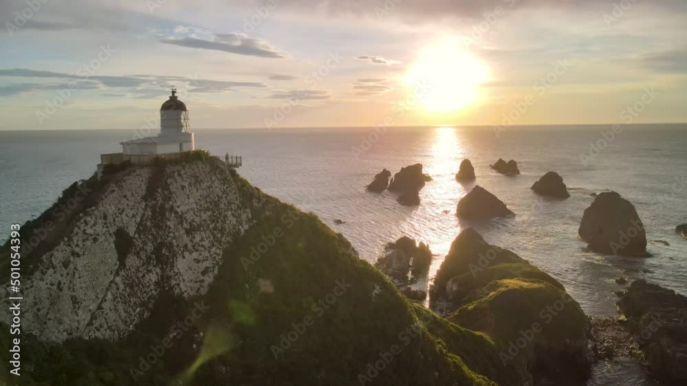 Beautiful scene of romantic sunrise at scenic spot with lighthouse and huge rocks on seaside. Nugget Point, New Zealand - aerial