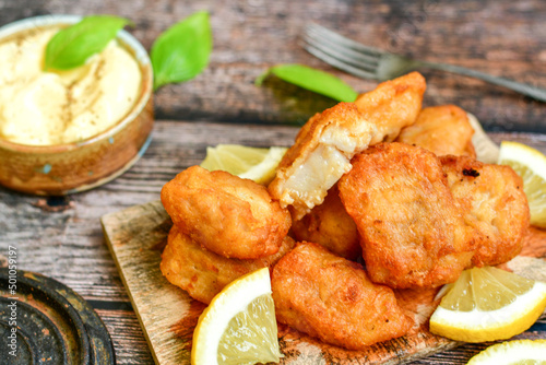   Allasca Pollock Fish  Bites in a crispy Tempura  Batter.Fish and chips .Close up of   crispy breaded  deep fried fish fingers with breadcrumbs s erved with remoulade sauce and  lemon