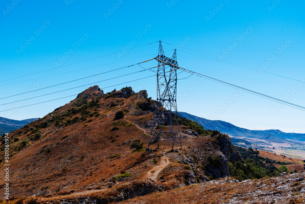 High voltage towers with hanging power cables in a rural landscape. Environmental issues, energy transportation
