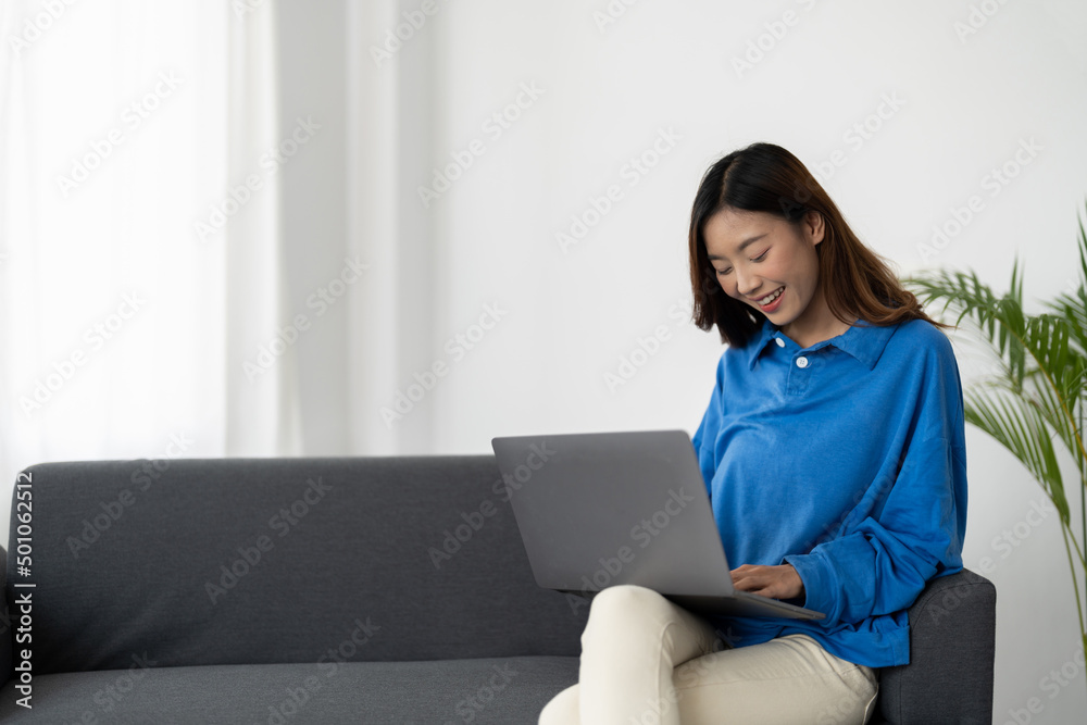 Young asian business woman smile and work from home with laptop computer online to internet on sofa in living room, freelance girl using notebook on couch with comfort, new normal, lifestyle concept Young asian business woman smile and work from home with laptop computer online to internet on sofa in living room, freelance girl using notebook on couch with comfort, new normal, lifestyle concept