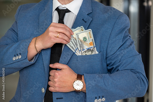 a man with a noble physique in a white shirt and tie shows a large sum of dollars in himself.