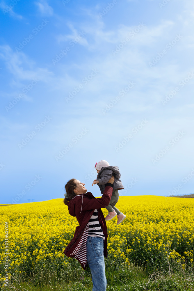 A baby and her mother enjoying a sunny day in the field A baby and her mother enjoying a sunny day in the field