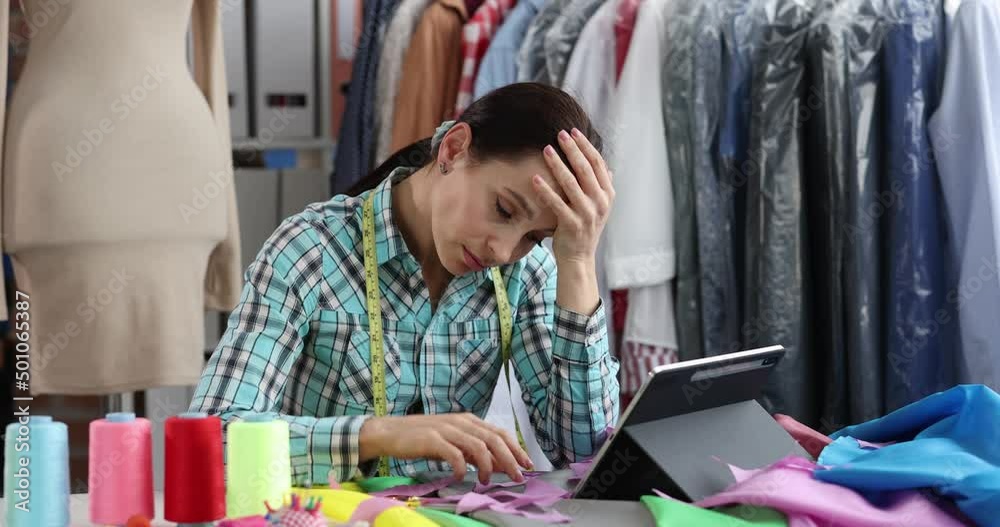 Upset sad seamstress designer stylist at workplace in atelier