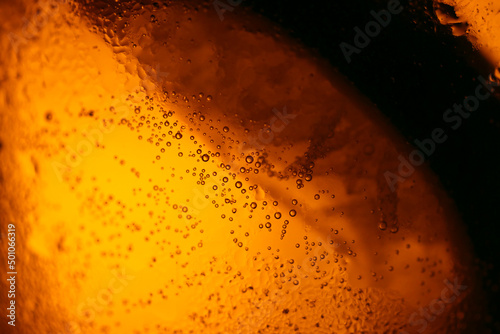 Amber back lighted frosty drink glass. Close up macro image texture. 琥珀色の冷たい酒、飲み物が入ったグラスを接写。シズル感と表面の霜のテクスチャー。 © SAIGLOBALNT