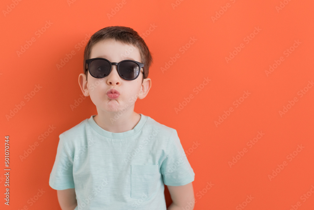Caucasian boy in sunglasses orange background Caucasian boy in sunglasses orange background