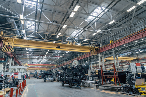 Big industrial factory. Manufacturing of agriculture machines. Workers and technique equipment in workshop.