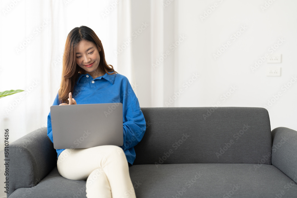Young asian business woman work from home with laptop computer online to internet on sofa, freelance girl using notebook on couch with comfort, new normal, lifestyle concept with copyspace Young asian business woman work from home with laptop computer online to internet on sofa, freelance girl using notebook on couch with comfort, new normal, lifestyle concept with copyspace