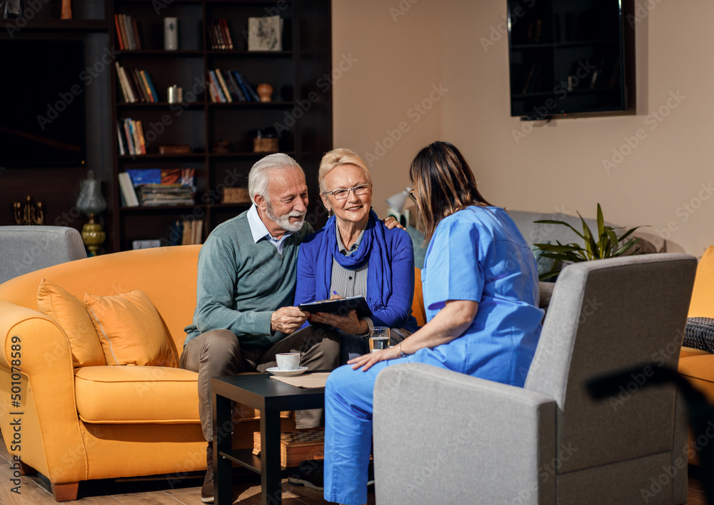 Female nurse talking to senior couple at nursing home. Female nurse talking to senior couple at nursing home.