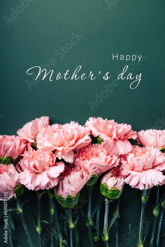 Pink carnations on turquoise green background with Happy Mother's Day inscription.